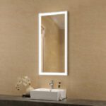 A bathroom with a large mirror above a sink.